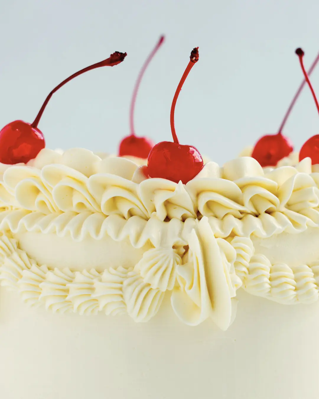 Stock photo: close-up of vintage ruffled buttercream piping topped with glossy red cherries