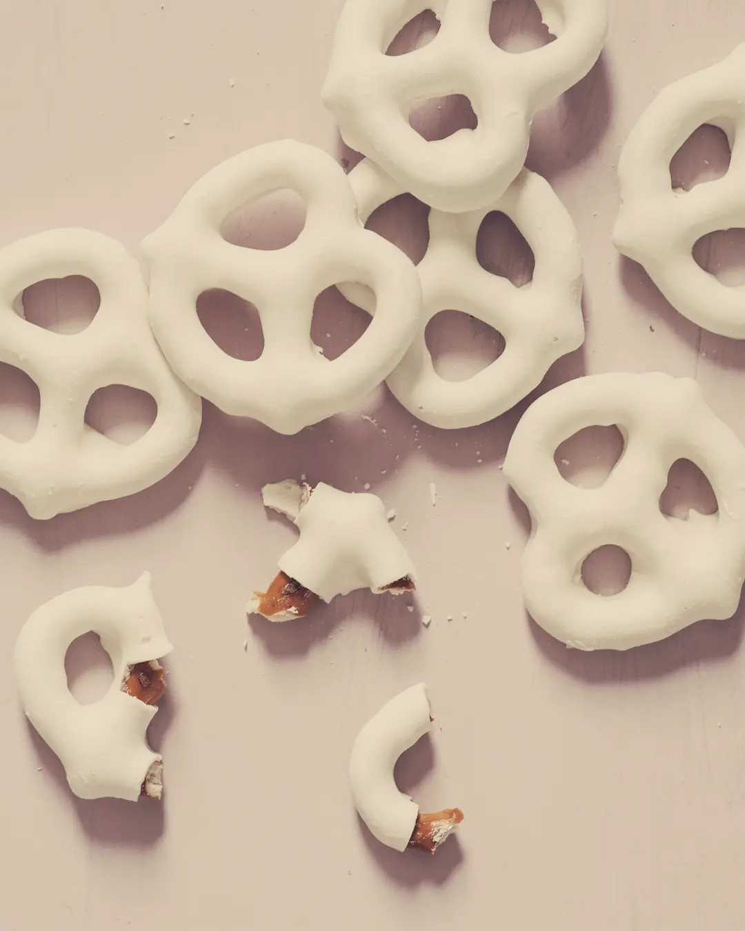 Stock photo: white candy-coated pretzels scattered on a soft pink background